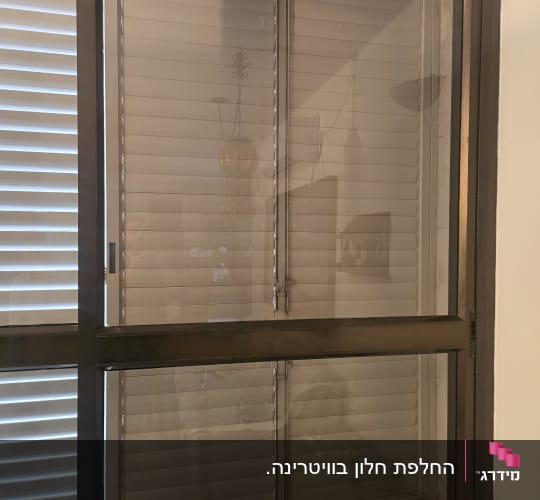חלון זכוכית שקוף במסגרת אלומיניום כהה בבית מגורים